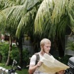 Map - Focused man studying map leaning on motorbike