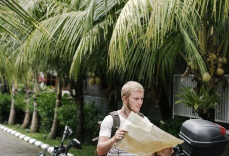 Map - Focused man studying map leaning on motorbike