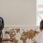Maps - Woman in White Shirt Sitting Beside Woman in Brown Shirt