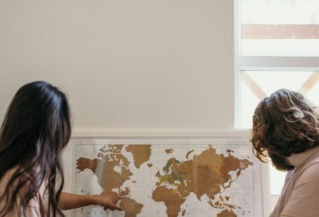 Maps - Woman in White Shirt Sitting Beside Woman in Brown Shirt