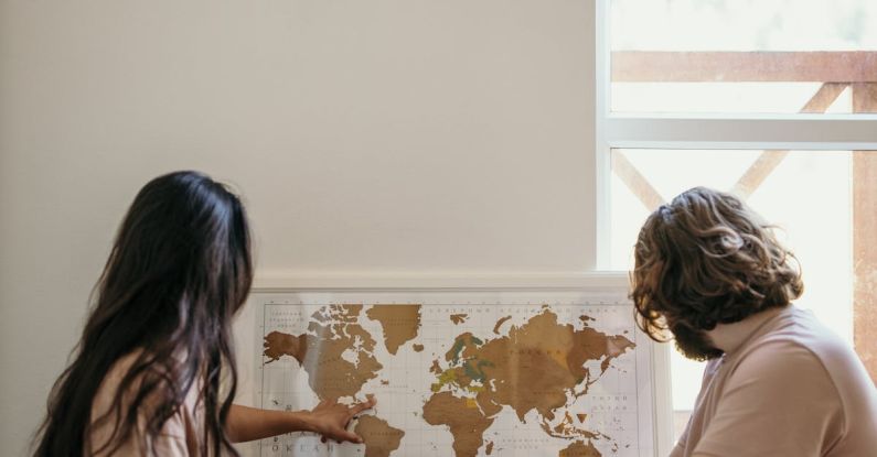 Maps - Woman in White Shirt Sitting Beside Woman in Brown Shirt