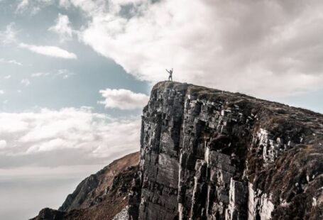 Elevation - Scenic Photo of Man Standing on Cliff Edge