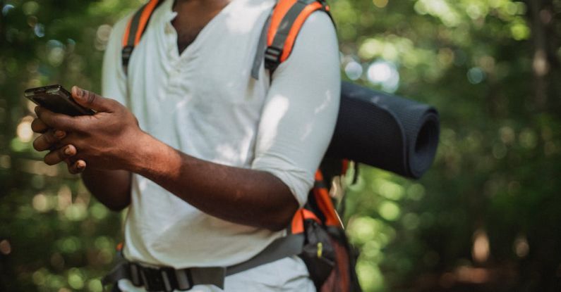 GPS Device - Crop hiker with smartphone in forest