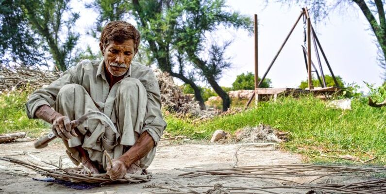 Survival Navigation Skills - Elderly Man Working with Wooden Sticks