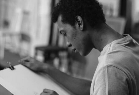 Field Sketching - Grayscale Photo Of A Man Sketching On White Cardboard