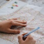 Sketching Maps - A Person Writing on a Paper Map