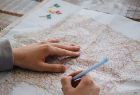 Sketching Maps - A Person Writing on a Paper Map