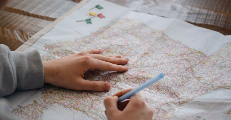 Sketching Maps - A Person Writing on a Paper Map